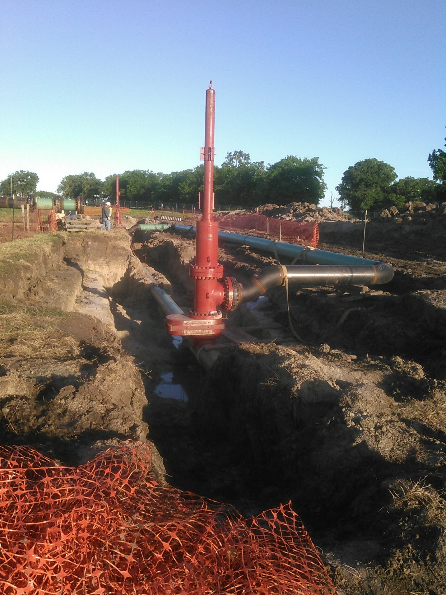 Buried pipeline tie-in with red riser valve assembly in the ditch